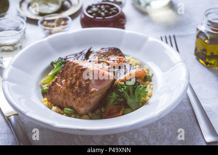 Salmon Fillet with Vegetables on Rustic White Plate Stock Photo