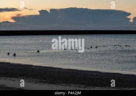 Sunderland, UK. 21st June, 2018. Summer solstice sunrise. A beatiful morning in the UK, the weather is calm for now. Swimmers take a dip in the North Sea as dawn begins to break Credit: Dan Cooke/Alamy Live News Stock Photo