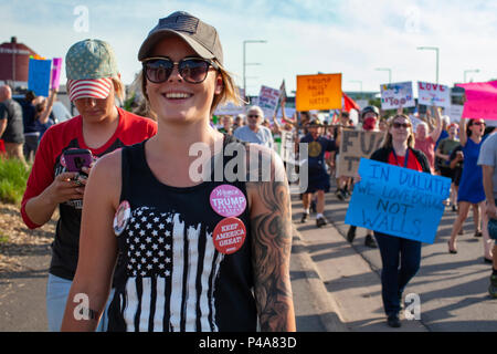 DULUTH, MINNESOTA, USA - June 20, 2018: A Trump supporter walks as a large crowd of protesters march in front of Amsoil arena while President Donald Trump speaks at a rally Wednesday night. Credit: Theresa Scarbrough/Alamy Live News Stock Photo