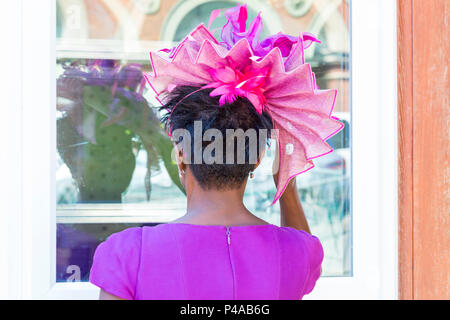 Ascot, Berkshire, UK. 21st June 2018. Racegoers arrive in Ascot in their hats and finery for Ladies Day at Royal Ascot as they make their way to the event. Fashion on Ladies Day Royal Ascot - woman wearing purple pink hat and dress, back rear view. Credit: Carolyn Jenkins/Alamy Live News Stock Photo