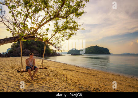 Young boy enjoys sunset n Ko Hong island in Thailand Stock Photo