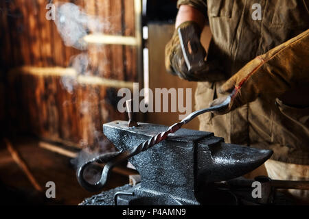 Blacksmith working on metal on anvil at forge high speed detail shot Stock Photo
