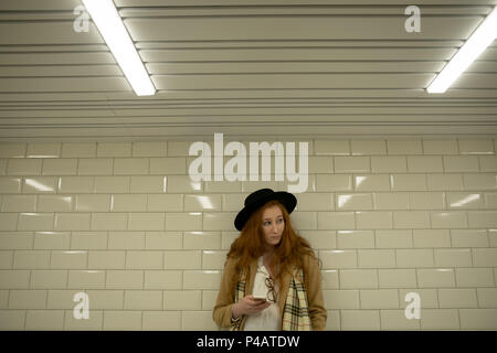 Woman using mobile phone in subway Stock Photo