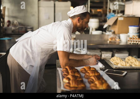 Male baker working in baker shop Stock Photo