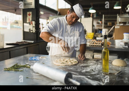 Male baker preparing dough in bakery shop Stock Photo