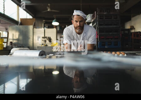 Male baker standing in bakery shop Stock Photo