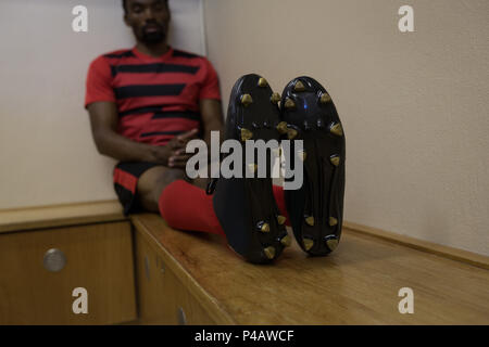 Football player relaxing on bench Stock Photo