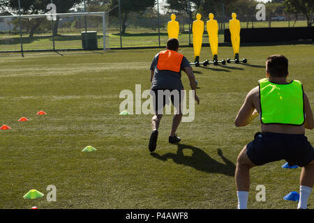 Football players practicing in the field Stock Photo