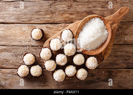 Delicious coconut kisses (beijinhos de coco or branquinhos)  - festive Brazilian sweets close-up on the table. horizontal top view from above Stock Photo