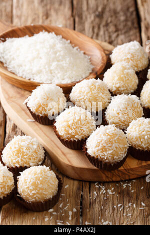 Delicious coconut kisses (beijinhos de coco or branquinhos)  - festive Brazilian sweets close-up on the table. vertical Stock Photo