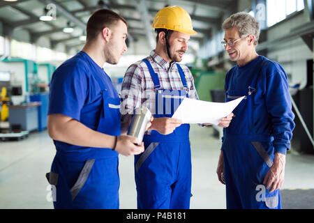 Team Of Engineers Having Discussion In Factory Stock Photo