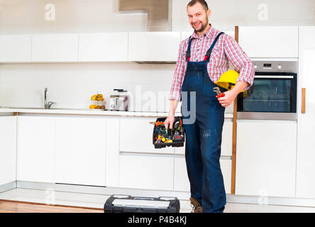 Workman holding his toolbox in the kitchen Stock Photo