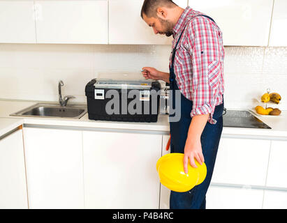 Workman holding his helmet in kitchen Stock Photo