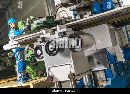 Heavy Duty Lathe Machinery Operator. Caucasian Metalworking Industry Worker in Front of the Machine. Stock Photo