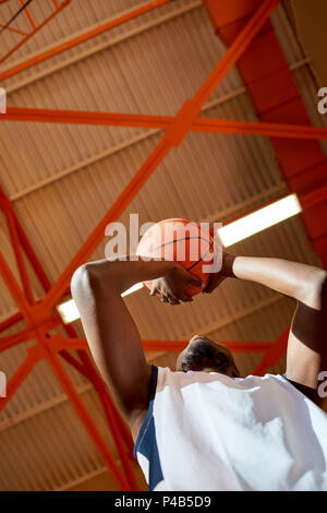 From below black man shooting goal Stock Photo