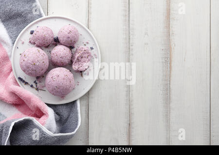 Handmade lavender bath bombs with towel on white planks Stock Photo