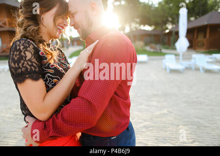 Bald european husband wearing red shirt and hugging wife. Stock Photo