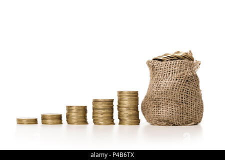 Plant growing in bag of coins Stock Photo