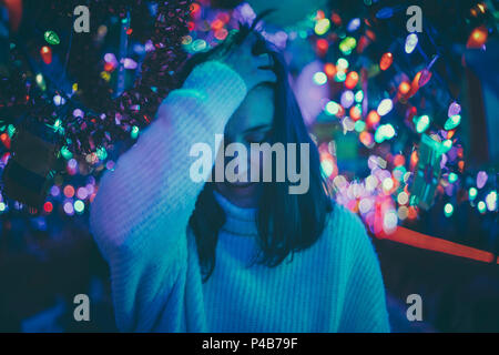 brunette woman moving her hair between Christmas lights Stock Photo