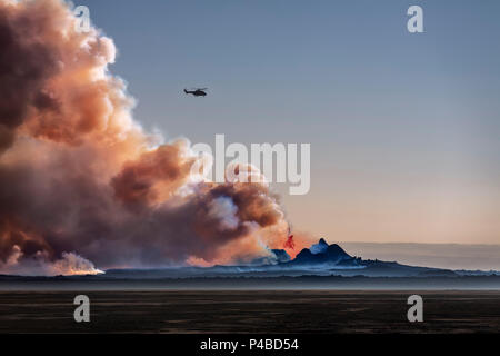 Helicopter flying over the volcano eruption at the Holuhruan Fissure, Bardarbunga Volcano, Iceland. August 29, 2014 a fissure eruption started in Holuhraun at the northern end of a magma intrusion, which had moved progressively north, from the Bardarbunga volcano, picture Date: Sept 20, 2014 Stock Photo