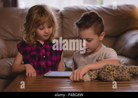 Boy and girl using digital tablet in living room Stock Photo