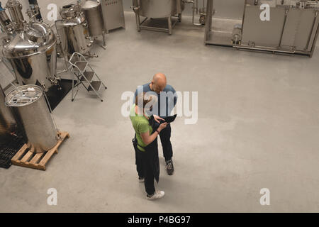 Two workers discussing over digital tablet Stock Photo