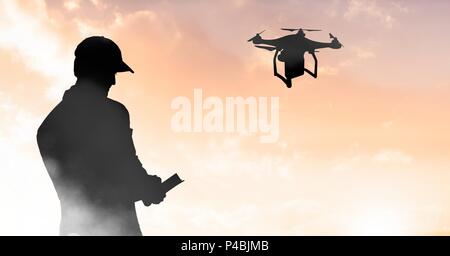 Man flying a drone silhouette in sky Stock Photo