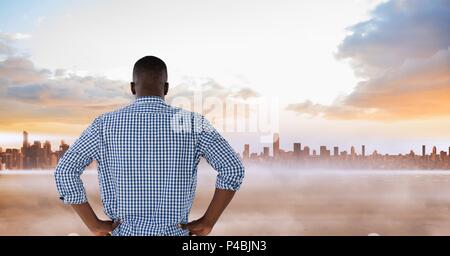 Composite image of back of man standing in front of skyline Stock Photo
