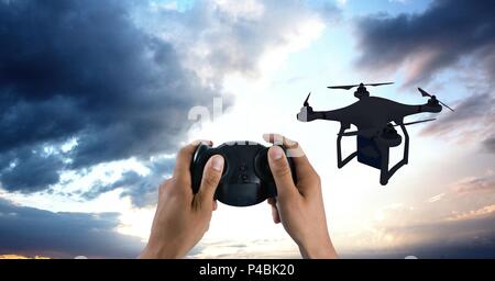 Man flying a drone silhouette in sky Stock Photo
