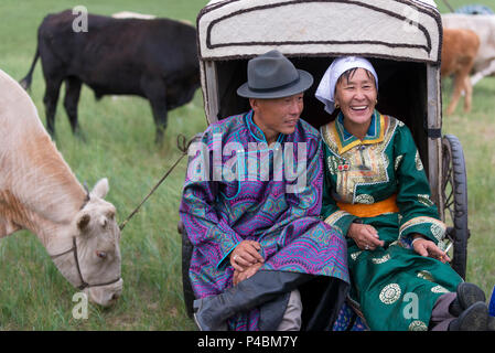 A Mongolian couple dressed in traditional costumes at their summertime grasslands camp, Inner Mongolia, China Stock Photo