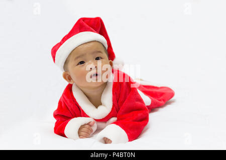 Asian cute new born baby with costume santa merry christmas xmas, on white bed background. Stock Photo