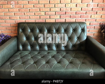 Vintage black leather texture sofa background, in the cafe. Stock Photo
