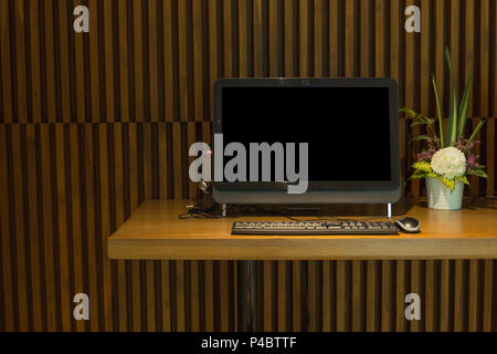 Black pc computer on modern wood table in the luxury cafe. Stock Photo