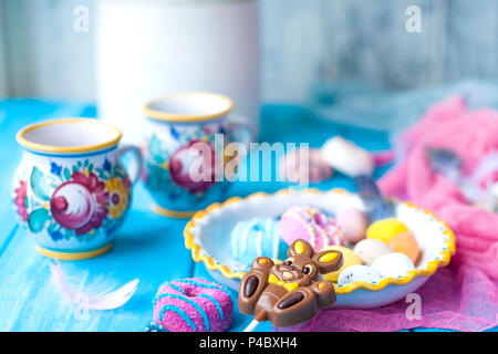 Easter sweets for the holiday. Spring. Bright colors on coffee mugs. Chocolate bunny. Stock Photo