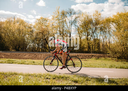 Cyclist rides on bicycle, side view Stock Photo