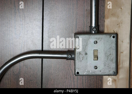 Old surface mounted metal electricity switch box and conduit pipe on a  wooden wall or panel Stock Photo - Alamy