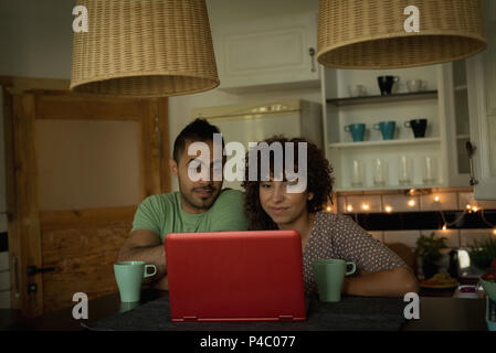 Couple using laptop while having coffee Stock Photo