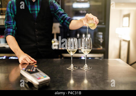 Pouring two glasses of white wine from a bottle in a close up vi Stock Photo