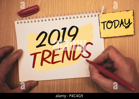 Text sign showing 2019 Trends. Conceptual photo New year developments in fashion Changes Innovations ModernMan creating for today on notebook Hand hol Stock Photo