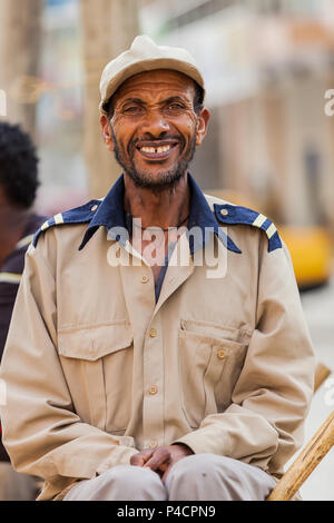 Addis Ababa, Ethiopia, January 27, 2014, Happy African man sitting on street corning smiling straight into the camera Stock Photo