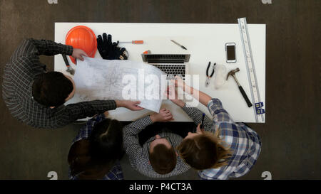 Group of architects discussing technical drawings Stock Photo