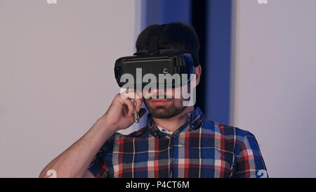 Serious young man in virtual reality glasses talking on the phone Stock Photo