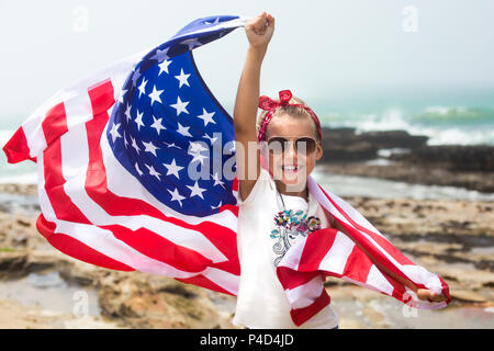 Smiling patriotic girl holds US flag celebrating national holiday Independence day on July 4th Stock Photo