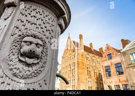 Water pump in the belgian city of Bruges decorated with a lions head Stock Photo