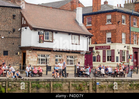 York, England, UK - August 05,  2011: People enjoying a quiet drink on the East Riverside of the River Ouse York which is often subject to flooding in Stock Photo