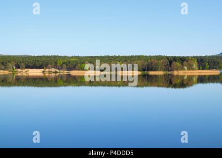 Lake with forest line mirrored into calm water surface. Cedzyna lake near Kielce. Poland, The Holy Cross Mountains. Stock Photo