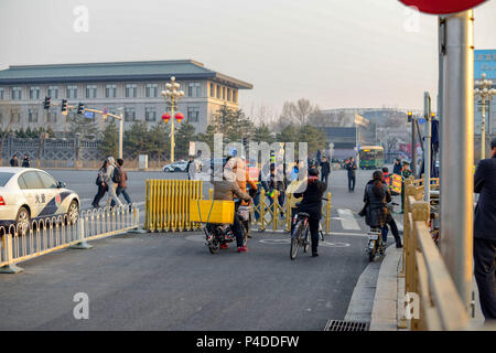 BEIJING, CHINA - MARCH 12, 2016: Pedestrians and cyclists crossing the Bejing Street intersection. Stock Photo