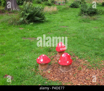 Dunkeld, Scotland, UK - August 16, 2013: Some garden mushroom carvings that have been thoughtfully carved out of fallen trees within the wooden areas  Stock Photo