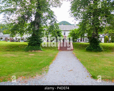 Dunkeld, Scotland, UK - August 16, 2013: The rear garden area of the Dunkeld House Hotel with people sitting in the patio areas surrounded by mature t Stock Photo