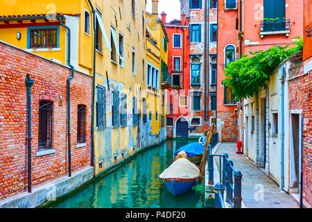Narrow side canal with moored motorboats in Venice, Italy Stock Photo